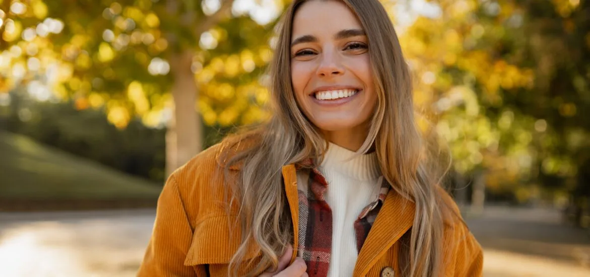 young beautiful blond woman walking in autumn park, stylish , smiling confidently